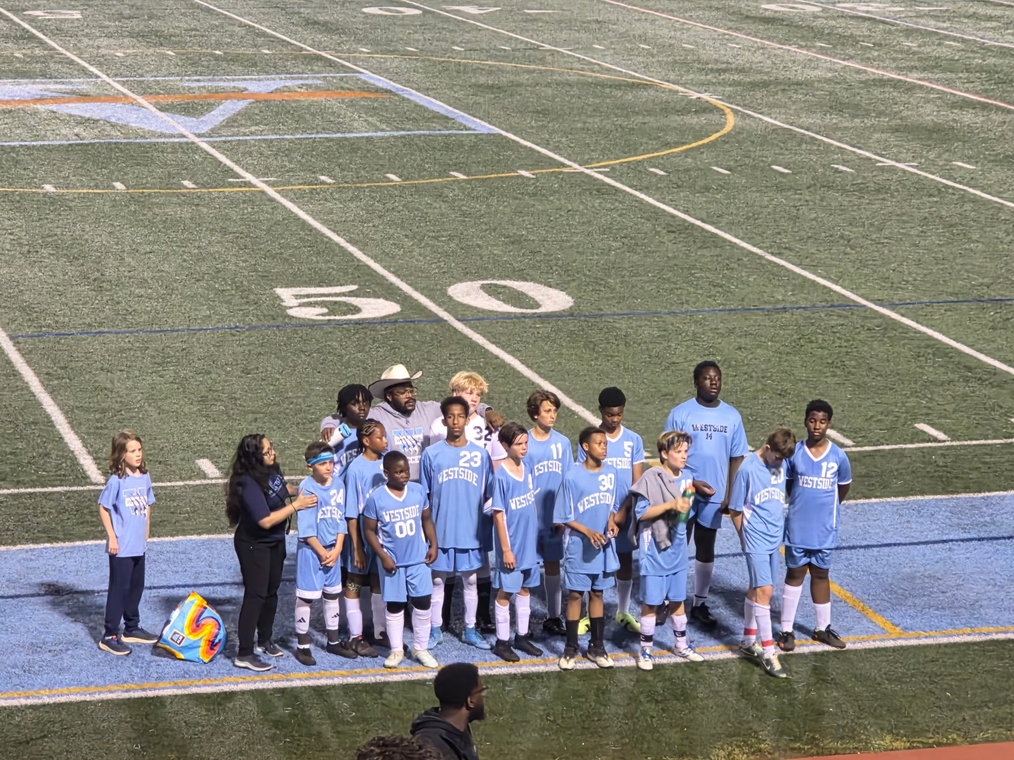 Westside soccer team lined up on the field with their coaches