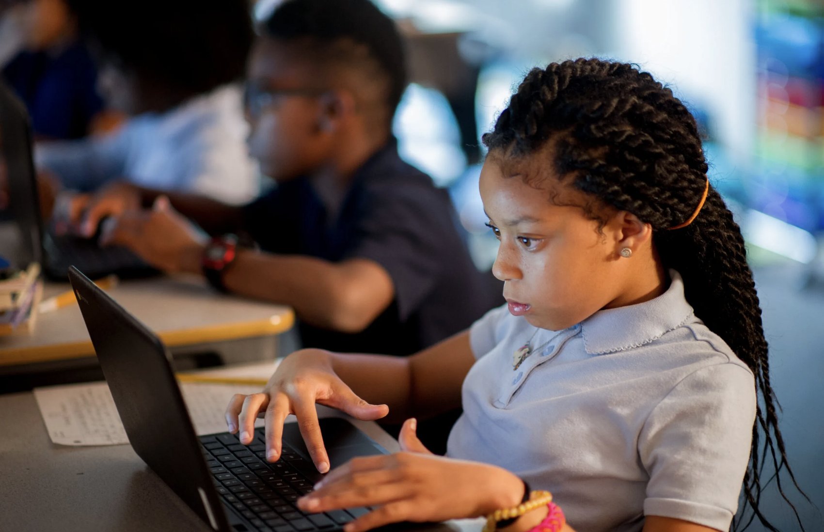 Students working on laptops in classroom